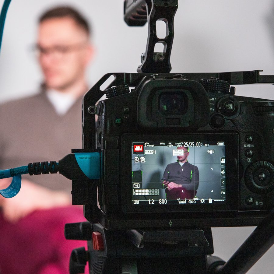 A cinema camera on set, with the subject in the background